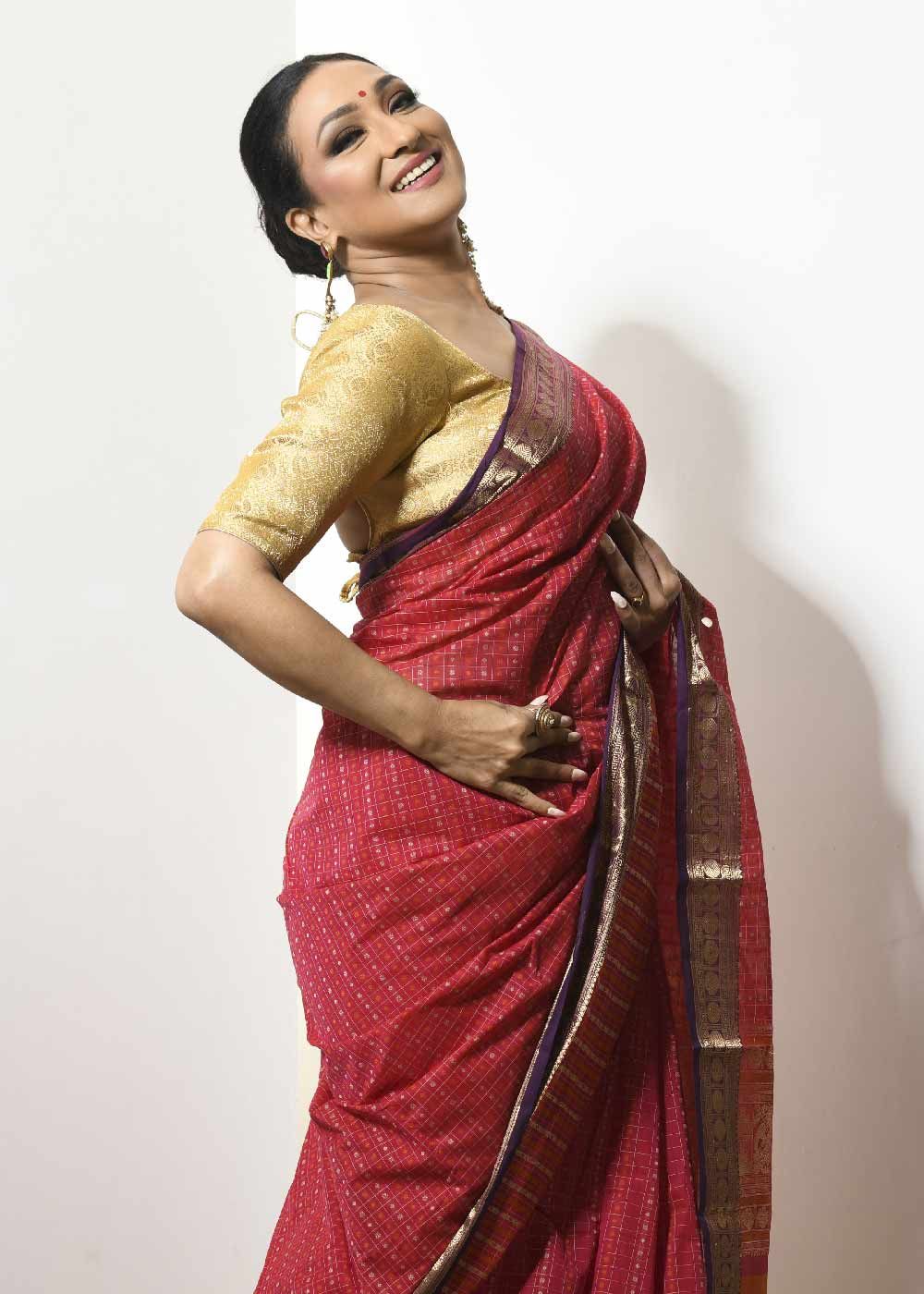 Rituparna is wearing golden blouse with red saree.